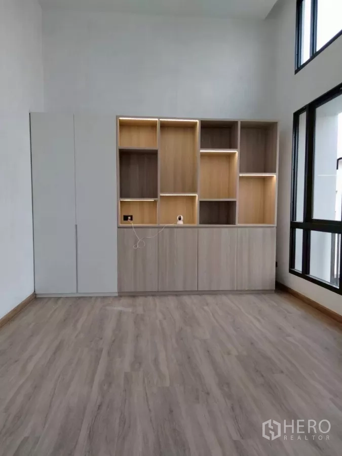 Townhouse for rent in Chatuchak, Bangkok - Built‑in shelves and cabinet unit in a bright room with large windows.