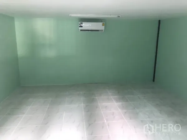货栈 出租在Nonthaburi - 仓库内的办公室，瓷砖地面与薄荷绿墙面，配空调。