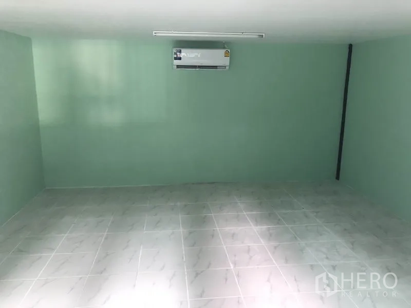 货栈 出租在Nonthaburi - 仓库内的办公室，瓷砖地面与薄荷绿墙面，配空调。