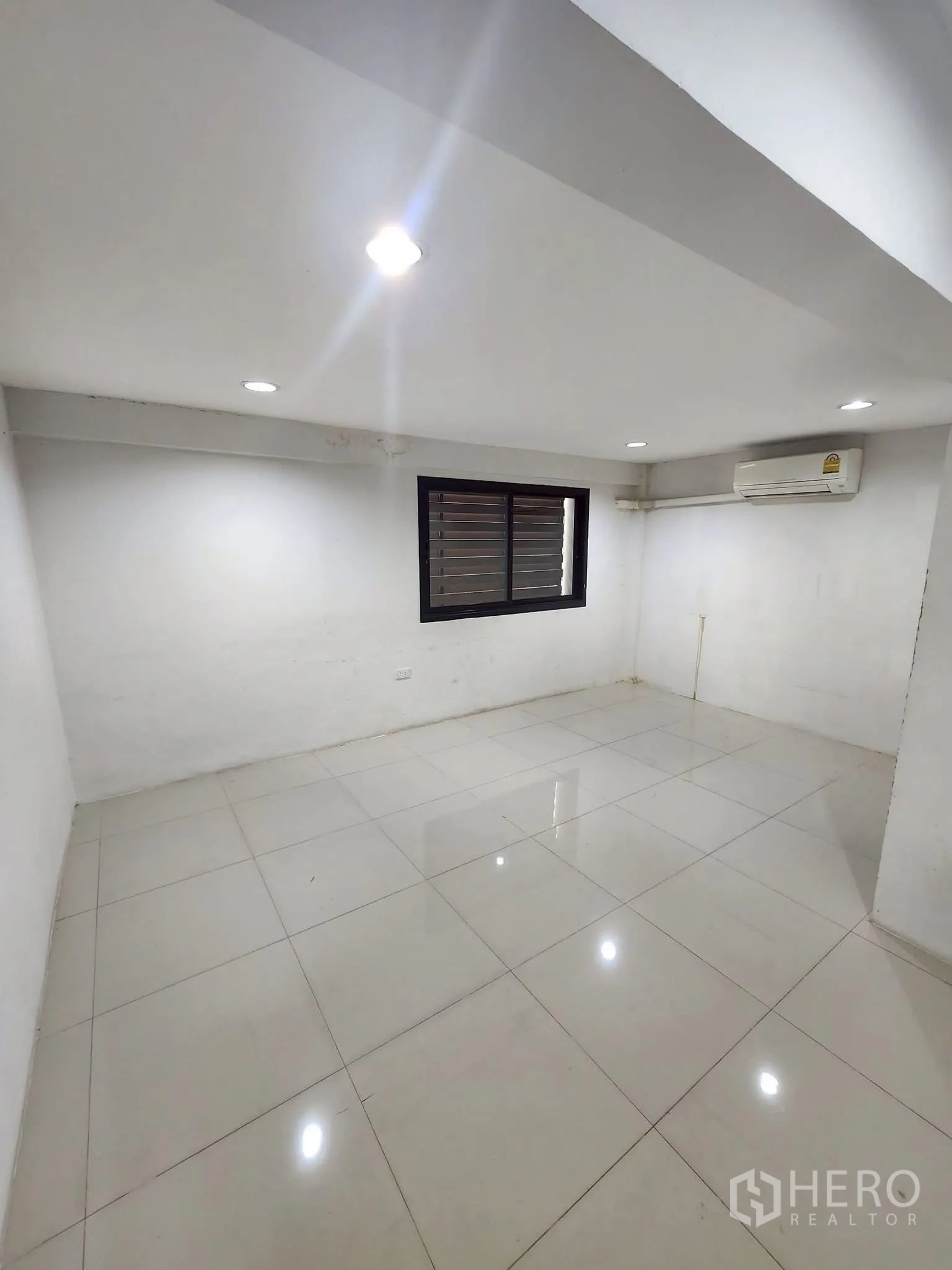 家庭办公室 for rent in Khlong Toei, Bangkok - 方正房间，亮面白砖地、百叶窗与挂壁空调。