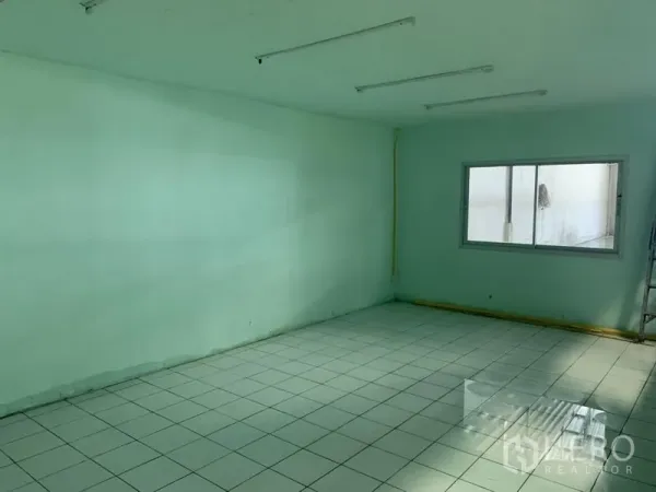 Warehouse for rent in Bueng Kum, Bangkok - Bright internal office with tiled flooring, window and fluorescent lighting inside the warehouse.