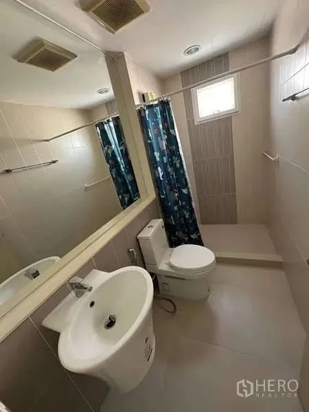 联排别墅 出租或出售在Wang Thonglang, Bangkok - 现代卫浴，立式洗手盆、马桶、大镜子与带浴帘的淋浴区，位于旺通郎联排别墅。