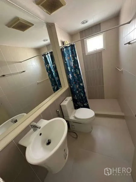 联排别墅 出租或出售在Wang Thonglang, Bangkok - 现代卫浴，立式洗手盆、马桶、大镜子与带浴帘的淋浴区，位于旺通郎联排别墅。
