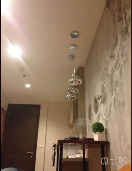 Condominium for sale in Phaya Thai, Bangkok - Entry area with pendant lights above a narrow bar table and textured wall finish.