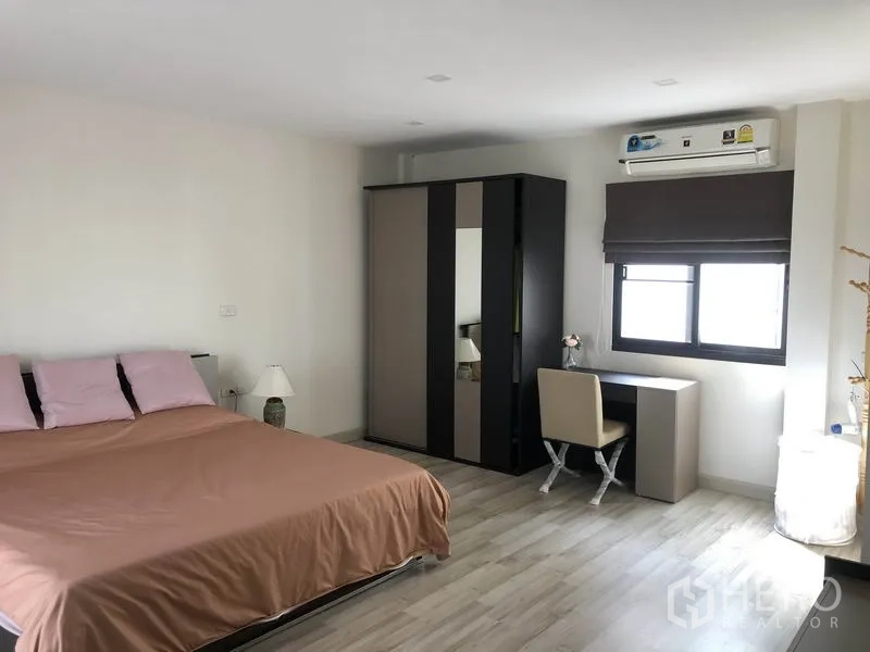 Townhouse for rent in Saphan Sung, Bangkok - Spacious master bedroom with bed, wardrobe, desk and air conditioning