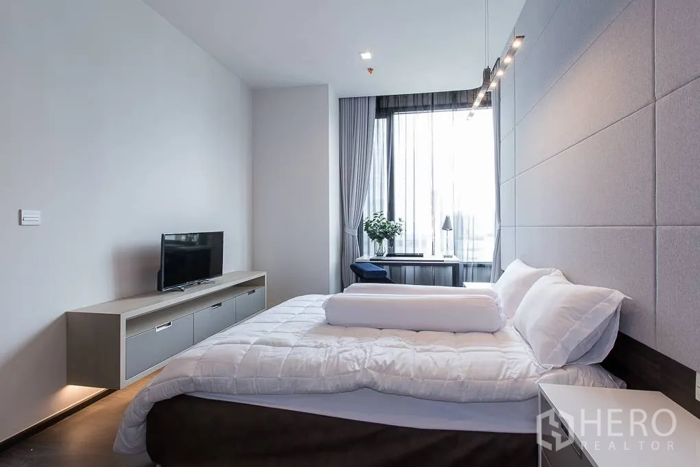 公寓 出租在Watthana, Bangkok - 宽敞卧室，软包特色墙、电视柜与通高窗户。