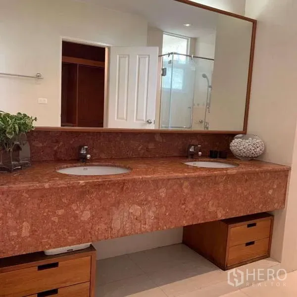 Detached House for rent in Lat Krabang, Bangkok - Primary bathroom with long marble double vanity, large mirror and storage drawers.