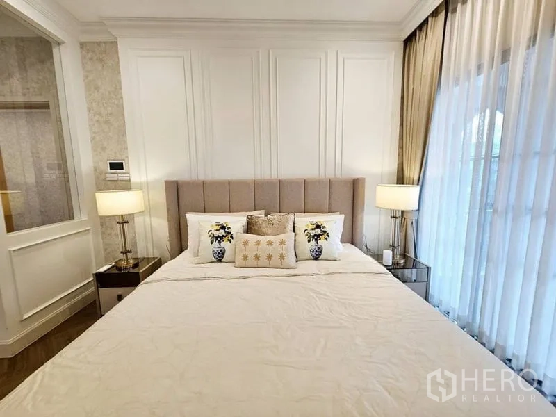 Detached House for rent or sale in Saphan Sung, Bangkok - Serene bedroom with paneled wall, matching bedside lamps and sheer curtains.