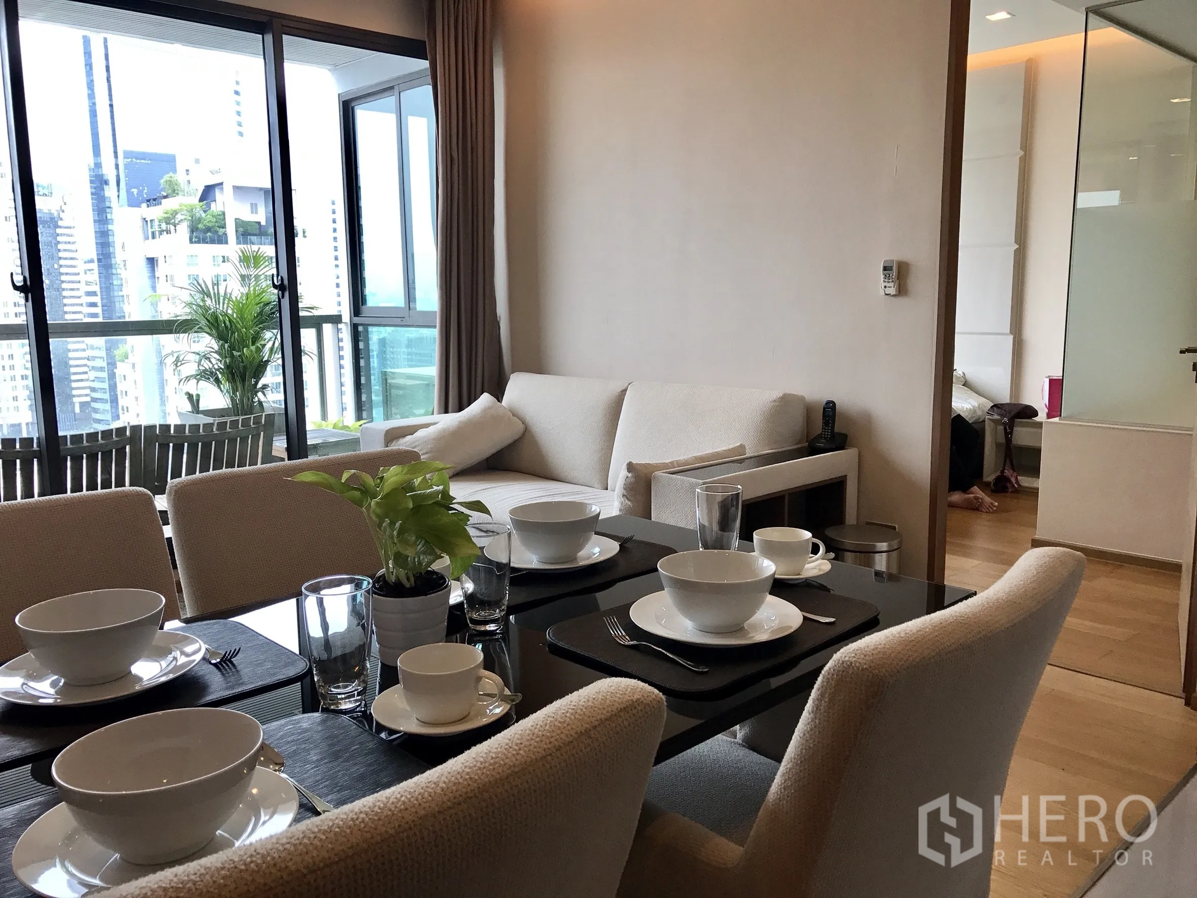 Condominium for rent or sale in Bang Rak, Bangkok - Open-plan living and dining area with balcony access and skyline views.