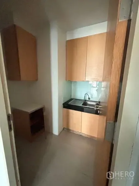 Office Space for rent in Bang Na, Bangkok - Compact pantry with sink, upper cabinets and countertop in light wood.