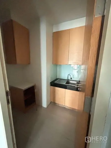 Office Space for rent in Bang Na, Bangkok - Compact pantry with sink, upper cabinets and countertop in light wood.