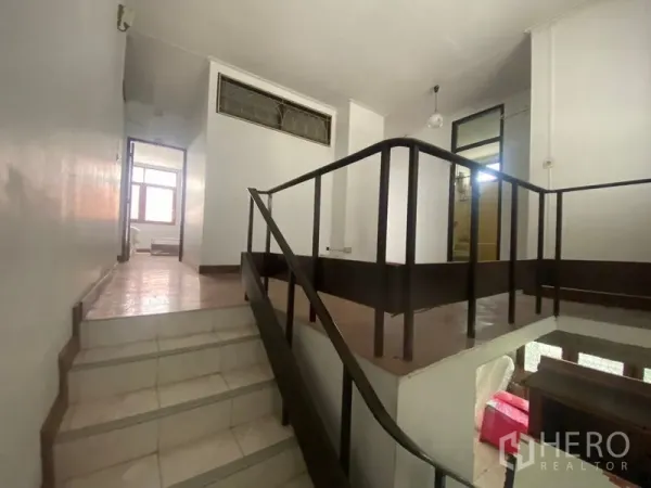 Home Office for rent in Khlong Toei, Bangkok - Mid-level landing with dark handrails and split-level steps.