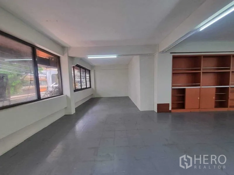 零售空间 出租在Bang Rak, Bangkok - 楼层另一角度，长窗与壁柜沿墙分布。
