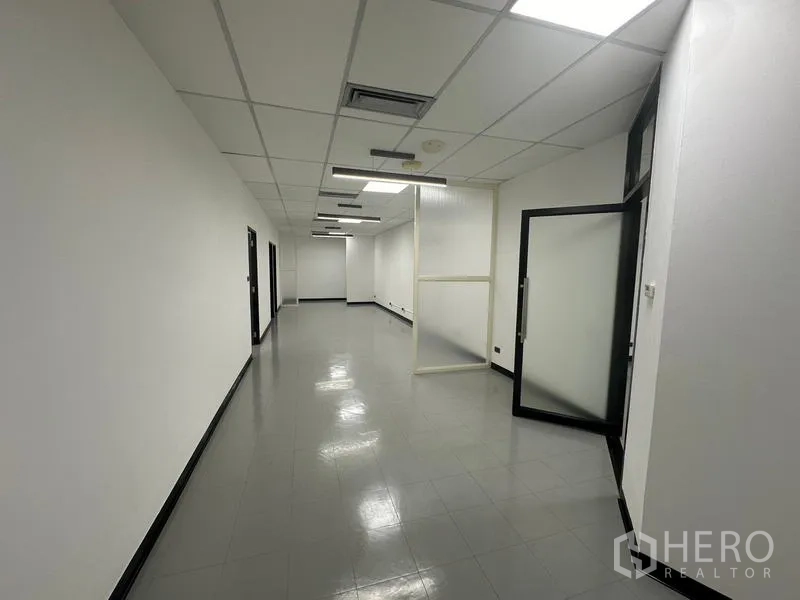Office Space for rent - Hallway-style workspace with glass entrance and suspended lighting.