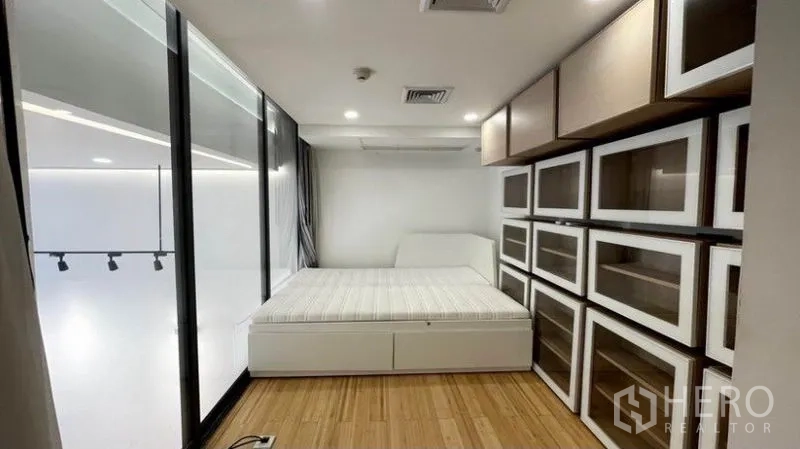 公寓 出租在Watthana, Bangkok - 夹层卧室带玻璃隔断俯瞰客厅，配大量收纳柜