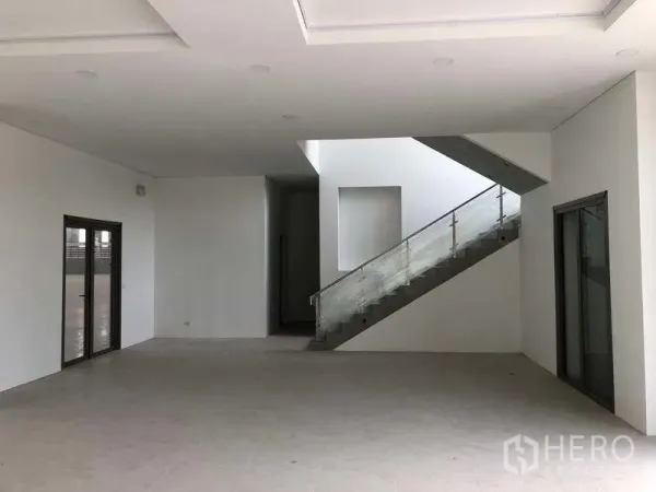 Factory for rent or sale in Samut Prakan - Spacious lobby area with glass-railed staircase and sliding glass doors.