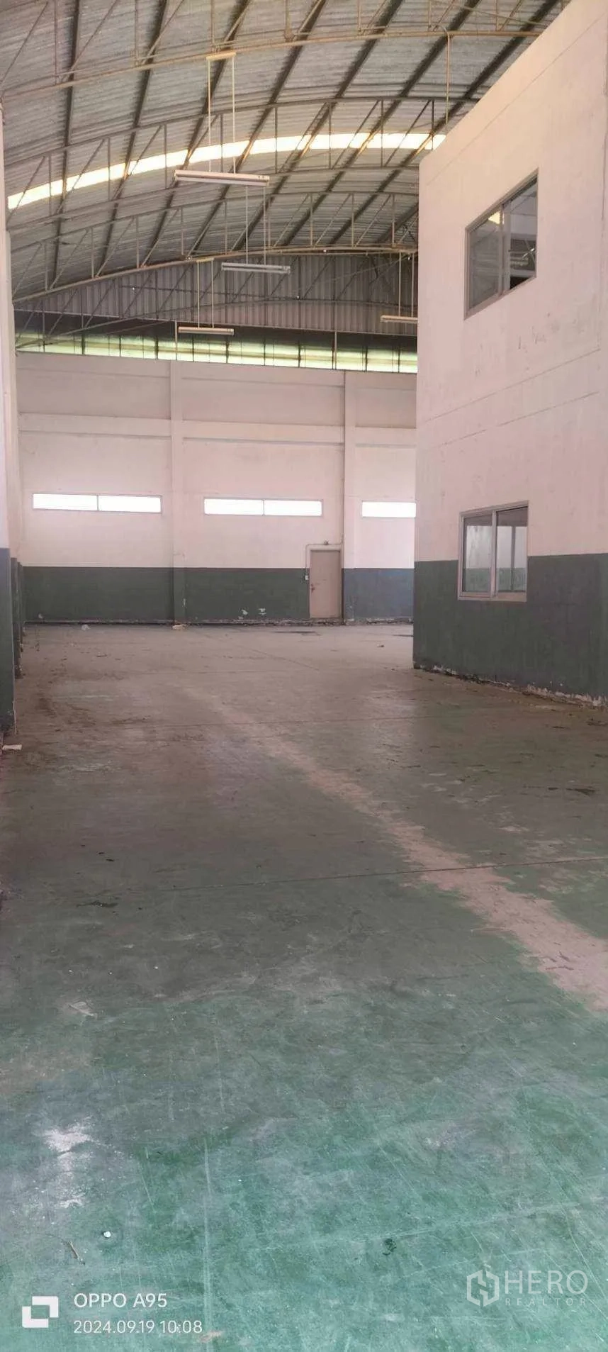 Factory for rent in Khlong Luang, Pathum Thani - Long aisle view of the warehouse under curved roof with skylight panels.