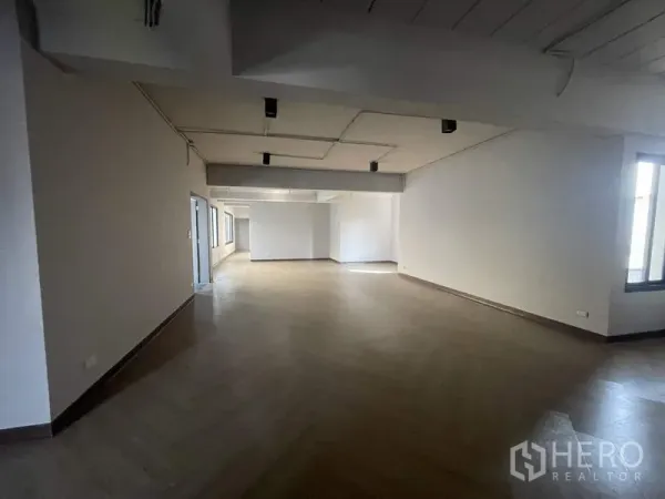 Home Office for rent in Phaya Thai, Bangkok - Long open office area with wood-effect flooring and ceiling spotlights.