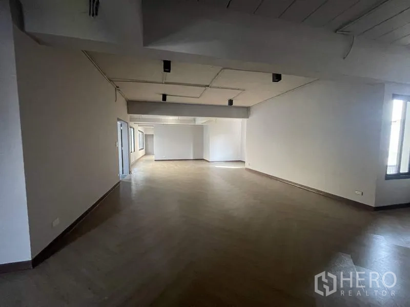 Home Office for rent in Phaya Thai, Bangkok - Long open office area with wood-effect flooring and ceiling spotlights.