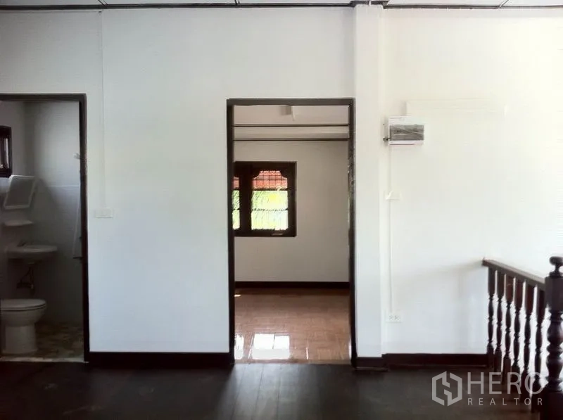Warehouse for rent in Lam Luk Ka, Pathum Thani - Upper-floor hallway with doorways leading to a room and a bathroom inside the warehouse.
