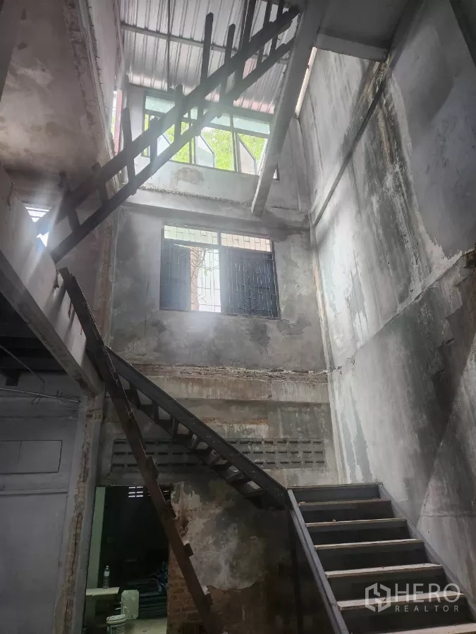 Shophouse for rent in Watthana, Bangkok - Tall atrium with metal staircases and windows bringing natural light inside.