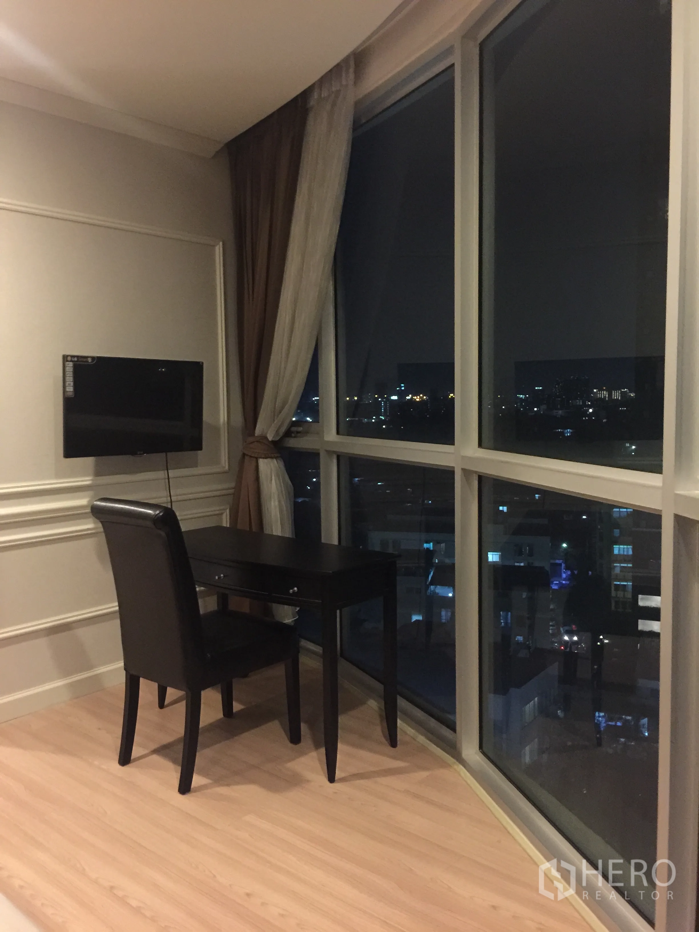 公寓 出租或出售在Watthana, Bangkok - 转角书桌临落地弧形窗，俯瞰曼谷夜景。