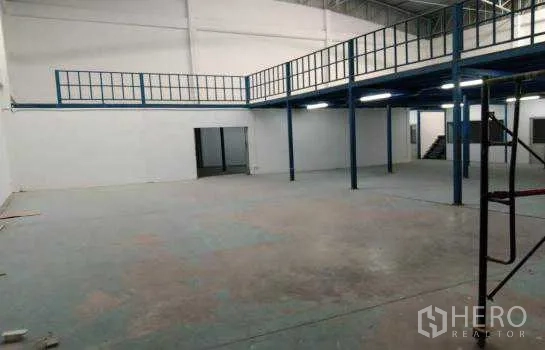 Warehouse for rent or sale in Prawet, Bangkok - High-clearance warehouse hall with a steel mezzanine for additional storage.