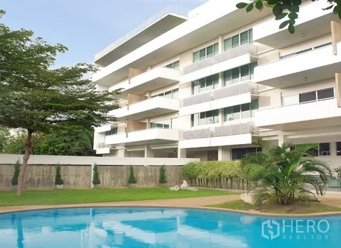 Apartment for rent in Khlong Toei, Bangkok - Low-rise apartment exterior with wide balconies overlooking the pool and garden
