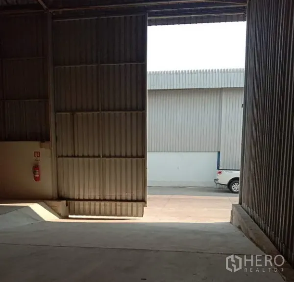 Warehouse for rent in Lat Krabang, Bangkok - Large sliding metal door with loading ramp opening to internal roadway for easy truck access.