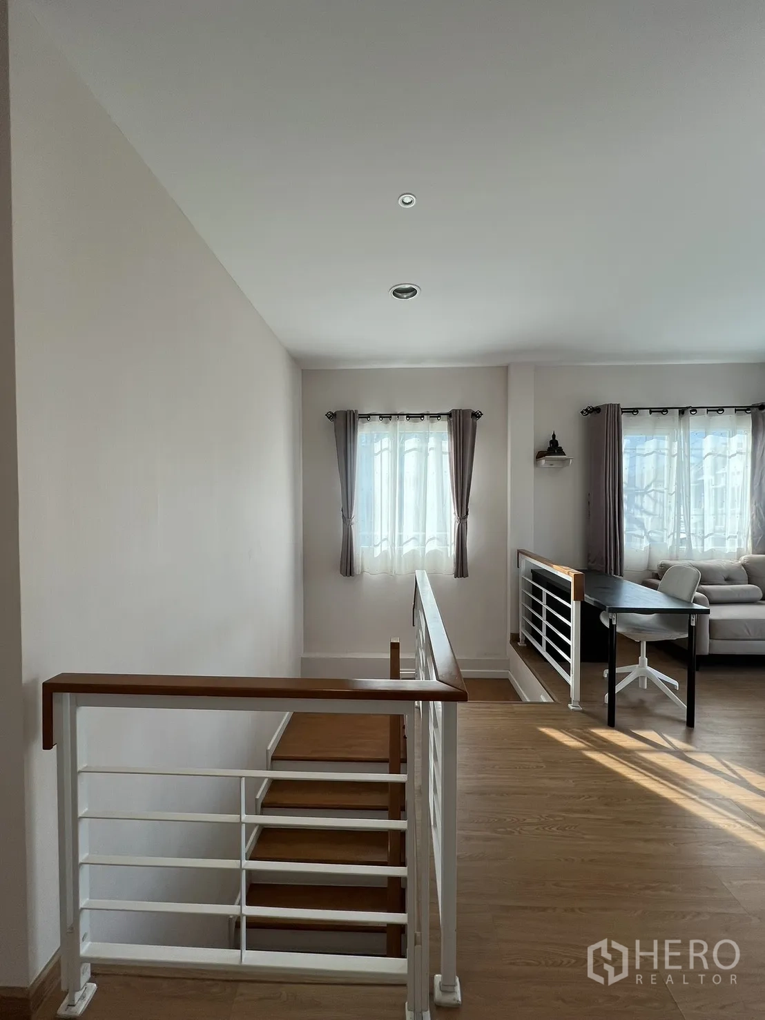 Detached House for rent in Bang Kapi, Bangkok - Upstairs landing with windows, a desk, and a sofa filled with natural light.