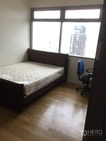 คอนโด ให้เช่าในWatthana, Bangkok - ห้องนอนขนาดกะทัดรัด มีเตียงและเก้าอี้ทำงานข้างหน้าต่างวิวเมือง