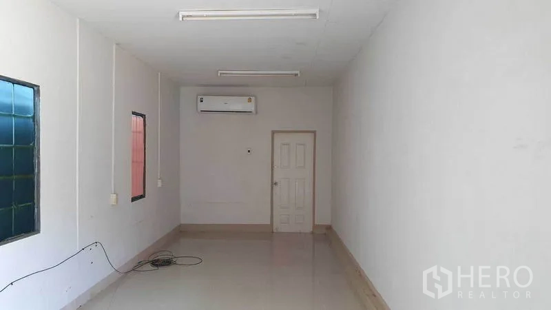 货栈 出租在Pathum Thani - 仓库内的空调办公室，白墙与瓷砖地面。