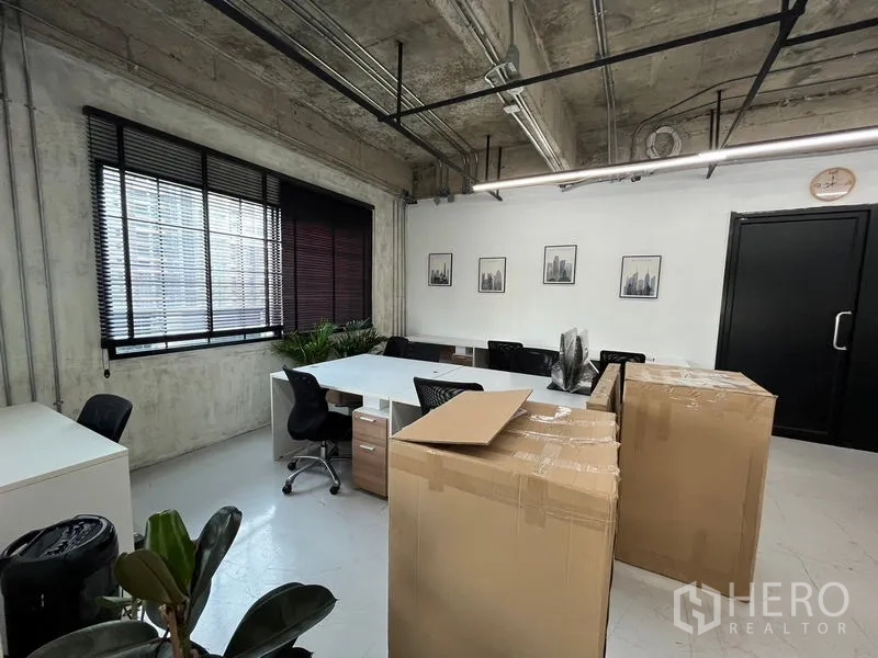 Office Space for rent in Khlong Toei, Bangkok - Workstation and meeting area by wide windows, white table, black chairs, framed art and a dark door.