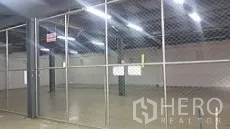工厂 出售在Lam Luk Ka, Pathum Thani - 厂房内设围栏的储物区，工业照明明亮。