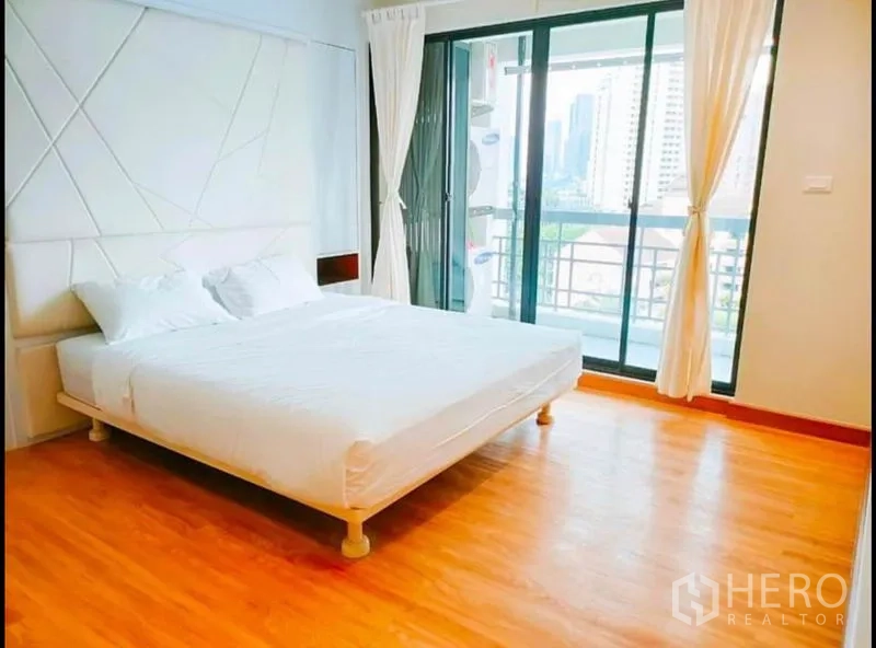 公寓 出售在Watthana, Bangkok - 宽敞主卧，双人床并连接阳台，远眺曼谷天际线。