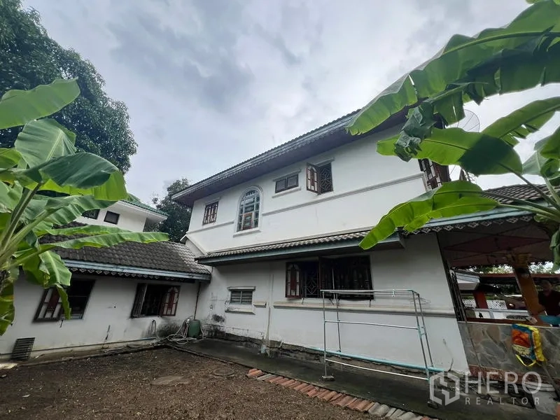 独立式住宅 出售在Phra Khanong, Bangkok - 两层住宅后立面，拱窗与花园空间一览。