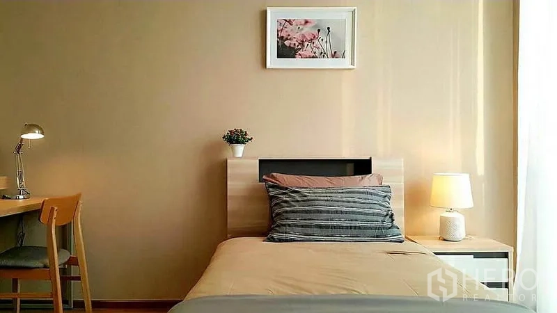 Condominium for rent in Khlong Toei, Bangkok - Cozy second bedroom with single bed, study desk and soft bedside lighting.