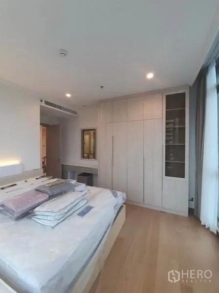 คอนโด ให้เช่าในWatthana, Bangkok - ห้องนอนหลักมีตู้เสื้อผ้าบิวท์อิน โต๊ะเครื่องแป้ง และหน้าต่างสูงจรดเพดานข้างเตียง