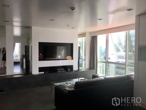 公寓 出租在Watthana, Bangkok - 客厅另一视角，嵌入式电视墙与转角窗景