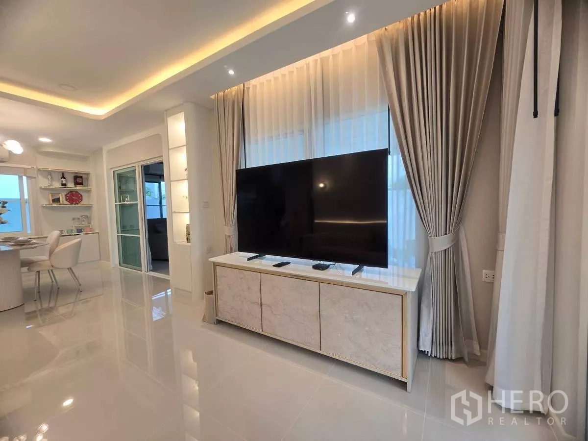 独立式住宅 出租在Bang Phli, Samut Prakan - 开放式客餐厅，大屏电视、筒灯与亮面地砖。