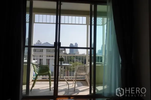 公寓 出租在Khlong Toei, Bangkok - 阳台休闲区，滑动落地门外的城市景观。