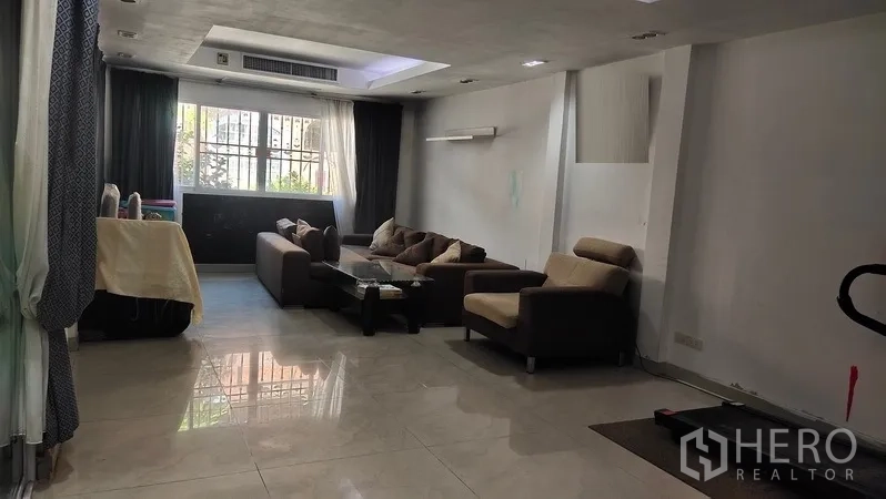 ทาวน์เฮาส์ ให้เช่าในWatthana, Bangkok - ห้องนั่งเล่นสว่าง ชุดโซฟา หน้าต่างบานใหญ่ และฝ้าเพดานซ่อนไฟ