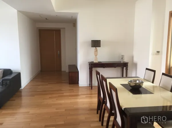 Condominium for rent in Khlong Toei, Bangkok - Dining area with six-seat table, entry hallway, and console table on light hardwood flooring.