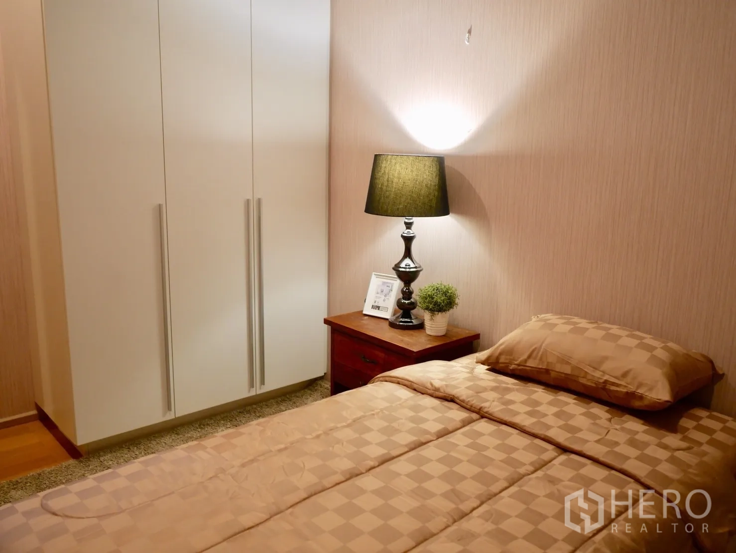 Condominium for rent in Watthana, Bangkok - Cozy second bedroom with wardrobe, bedside table and warm lighting.