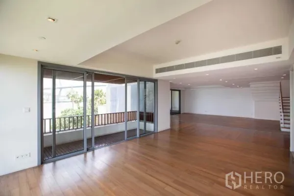 公寓 出租在Yan Nawa, Bangkok - 开放式起居区，推拉落地门连接带顶阳台，宽木地板