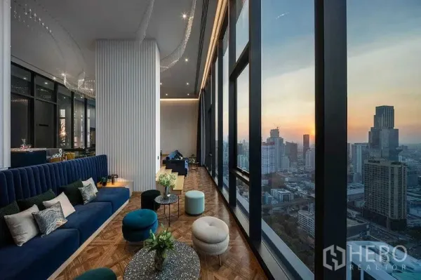 Condominium for rent in Ratchathewi, Bangkok - High-rise sky lounge with floor-to-ceiling windows and sunset skyline over Bangkok.