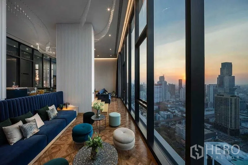 Condominium for rent in Ratchathewi, Bangkok - High-rise sky lounge with floor-to-ceiling windows and sunset skyline over Bangkok.