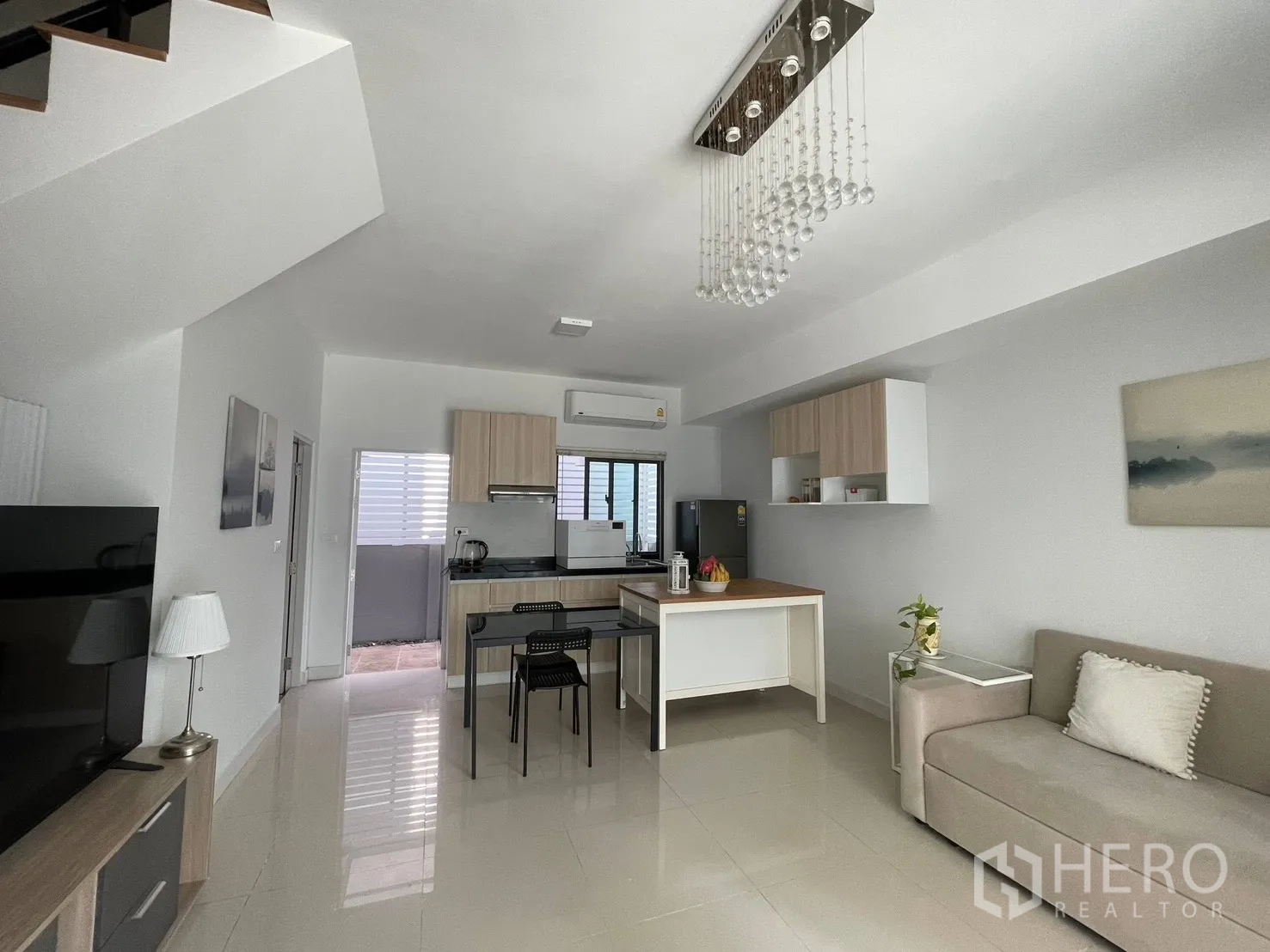 ทาวน์เฮาส์ for rent in Bang Phli, Samut Prakan - มุมกว้างพื้นที่นั่งเล่น โคมแชนเดอเลียร์ บันได ครัวโมเดิร์น และพื้นกระเบื้องมันวาว
