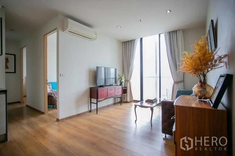 Condominium for sale in Khlong Toei, Bangkok - Living area with media unit and bedroom access, featuring full-height glazing.