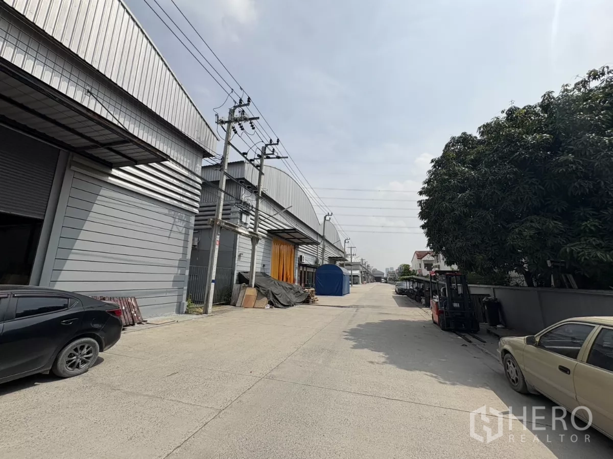 货栈 出租在Bang Phli, Samut Prakan - 园区内部道路，两侧为金属仓库与电线杆。